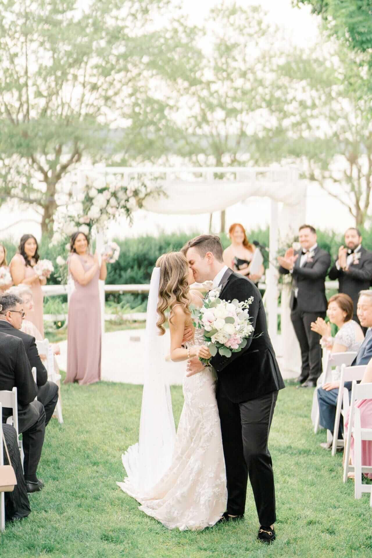 A man and woman kissing in front of a crowd of people.
