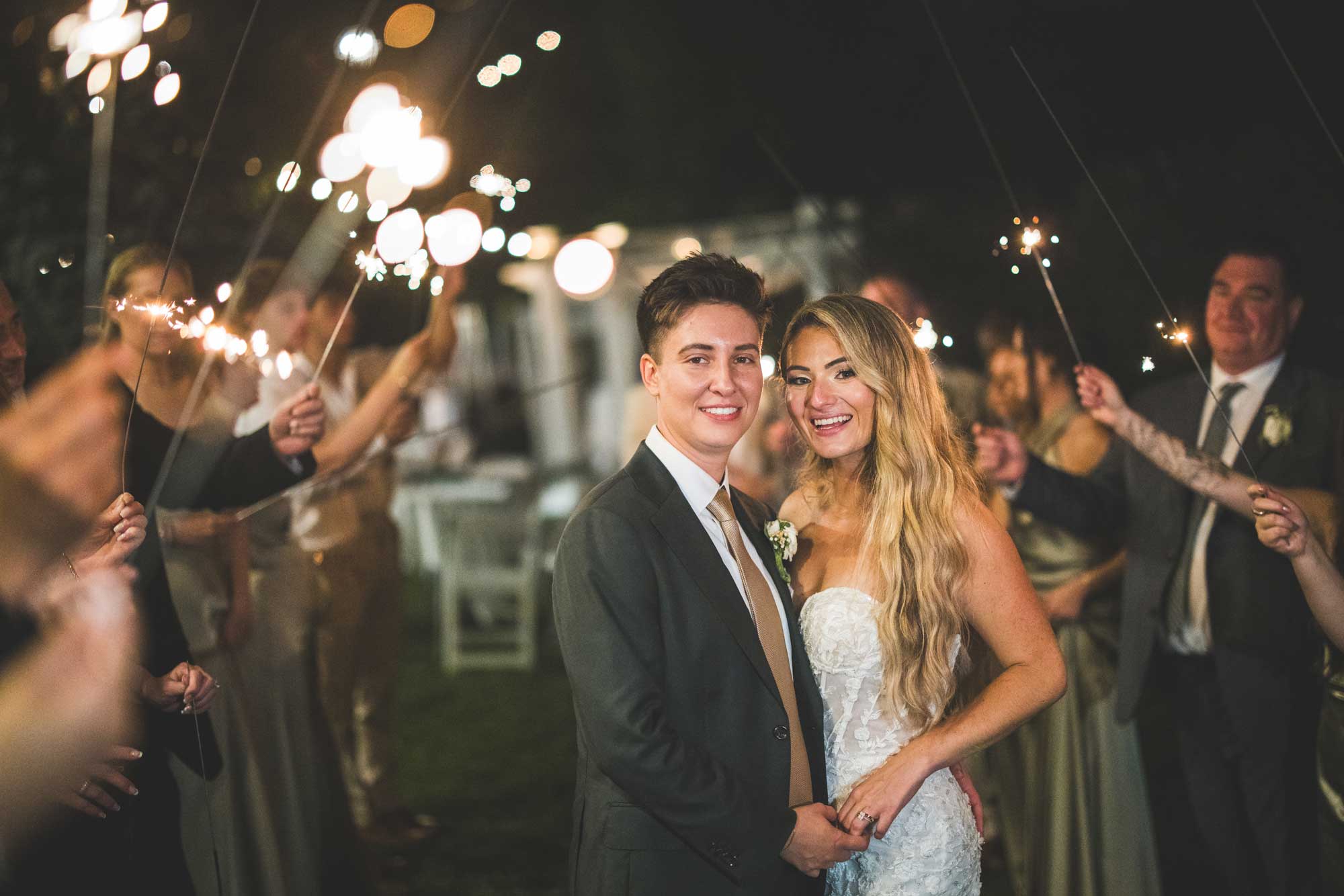 brides-exit-with-sparklers-at-sea-cliff-manor A man and woman holding each other.