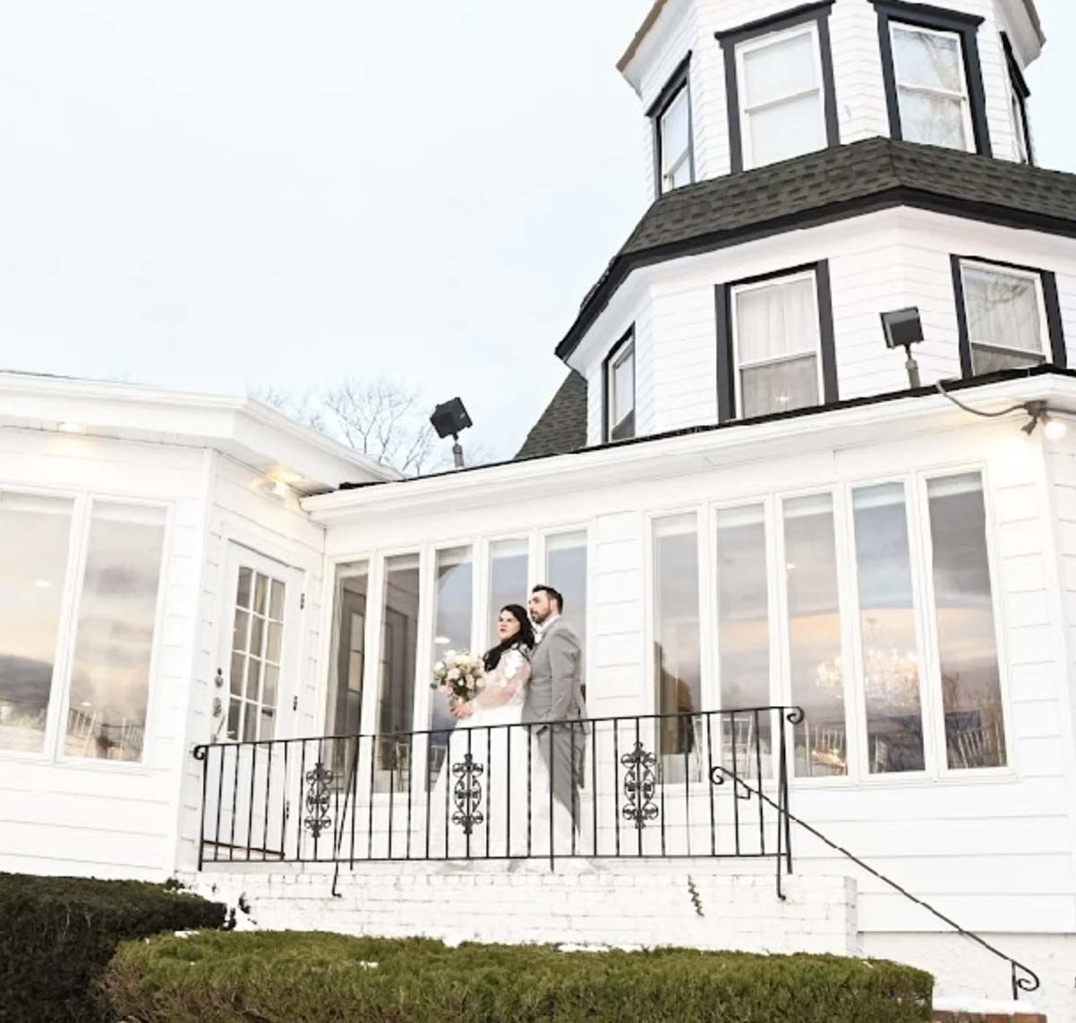 testimonial-angela-d A man and woman standing on a balcony of a house.