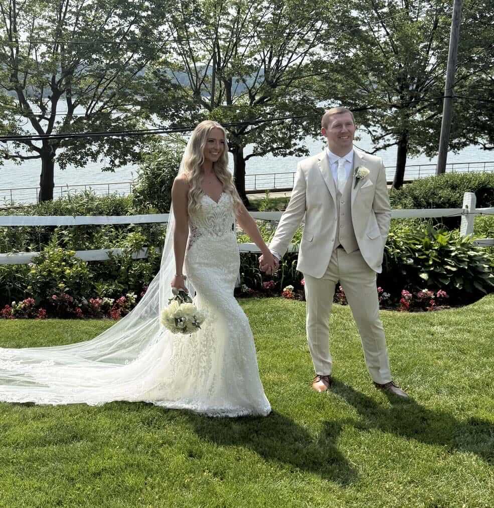 testimonial-heather-o A man and woman in a white suit holding hands.